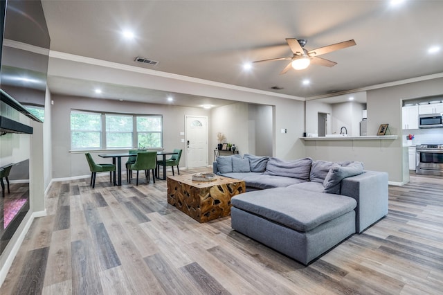 3467 Navajo Cir, Dallas, TX 75224 - living area featuring light wood-type flooring, ornamental molding, recessed lighting, and ceiling fan