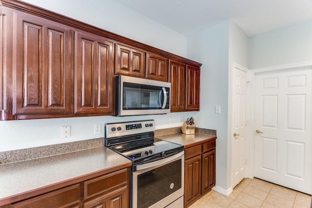 kitchen featuring stainless steel appliances and light tile patterned flooring