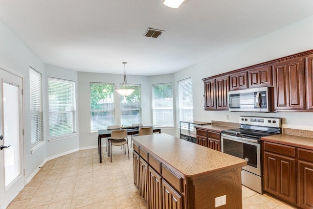 kitchen with visible vents, a center island, light countertops, appliances with stainless steel finishes, and decorative light fixtures