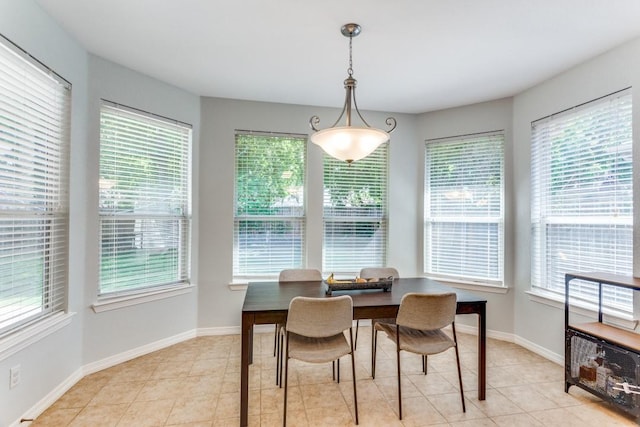dining area featuring baseboards, light tile patterned flooring, and a healthy amount of sunlight