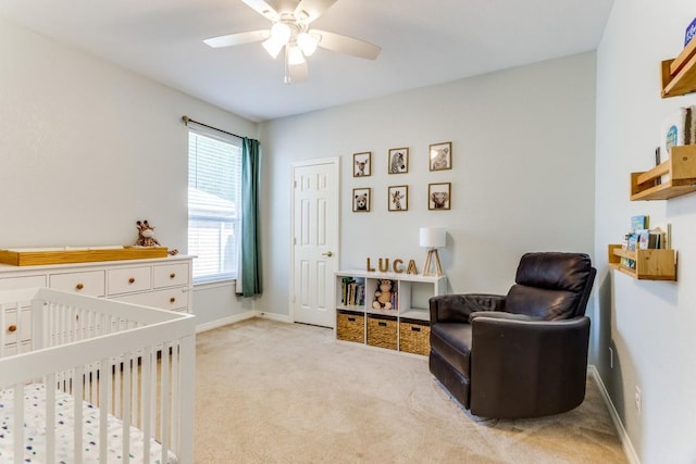 bedroom with carpet floors, a ceiling fan, baseboards, and a nursery area