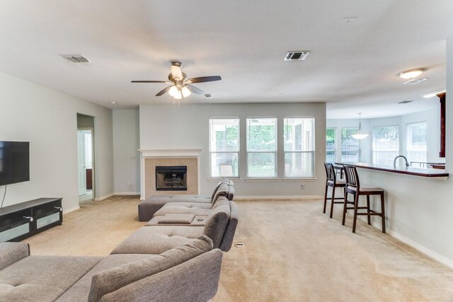 living area featuring light colored carpet, baseboards, and visible vents