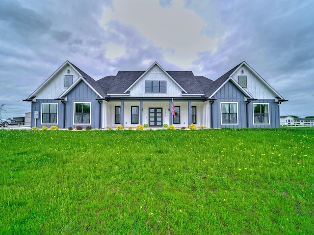 modern farmhouse style home featuring a shingled roof, covered porch, board and batten siding, and a front lawn