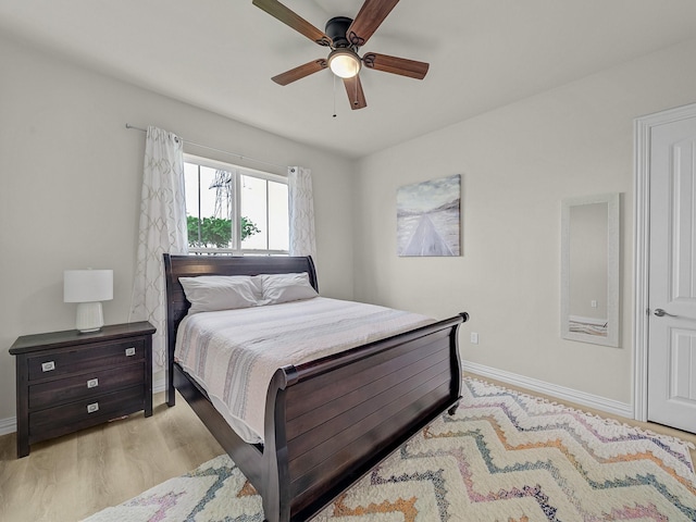 bedroom with baseboards, ceiling fan, and wood finished floors