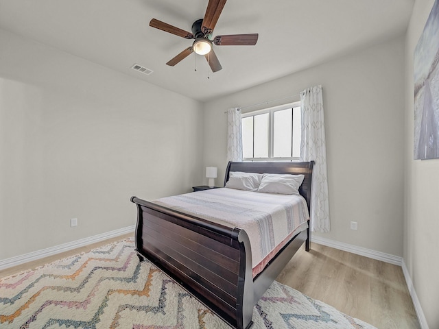 bedroom with visible vents, baseboards, ceiling fan, and light wood-style floors