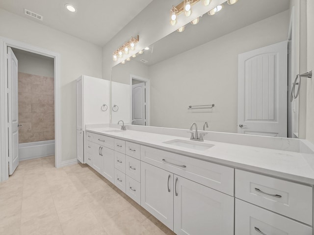 bathroom with double vanity, visible vents, a sink, and tile patterned flooring