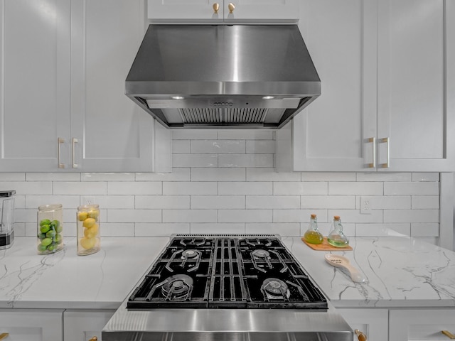 kitchen with stovetop with downdraft, white cabinetry, and exhaust hood