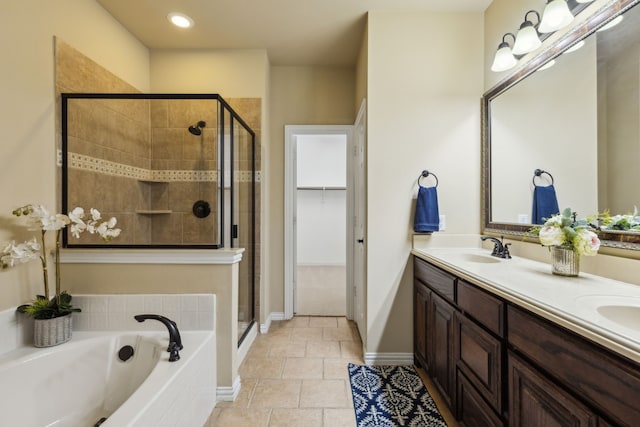 full bathroom featuring a sink, tile patterned flooring, double vanity, a shower stall, and a garden tub