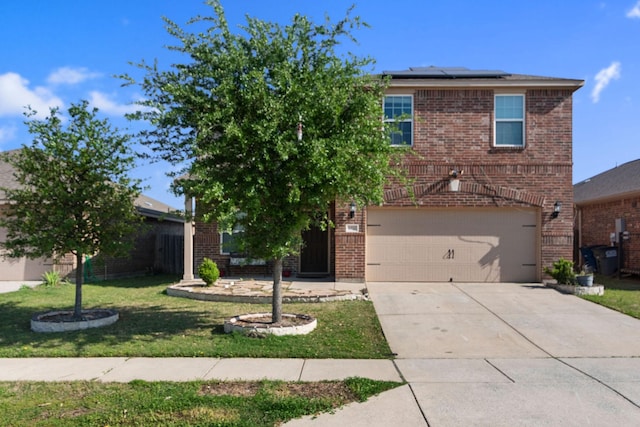 1320 Corkwood Dr, Princeton, TX 75407 - view of front of home with a front yard, brick siding, roof mounted solar panels, an attached garage, and driveway