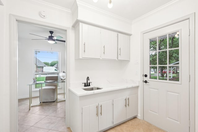 interior space with crown molding, light tile patterned flooring, a ceiling fan, and a sink