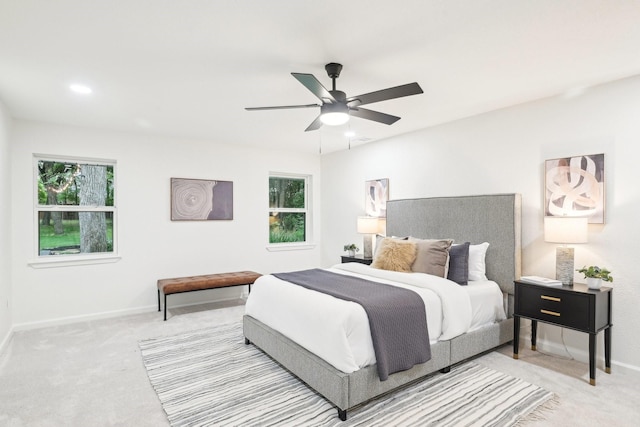 carpeted bedroom with baseboards, multiple windows, and ceiling fan