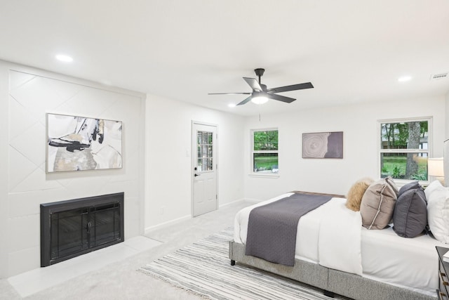 bedroom featuring multiple windows, carpet, recessed lighting, and a tile fireplace