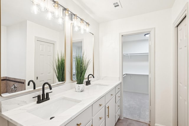 bathroom featuring a sink, tile patterned floors, double vanity, and visible vents