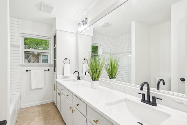 bathroom featuring double vanity, a sink, and tile patterned floors