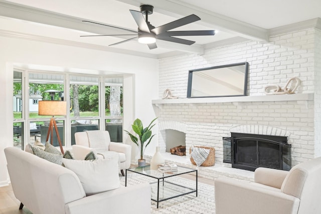 living room featuring beamed ceiling, ceiling fan, a fireplace, and wood finished floors