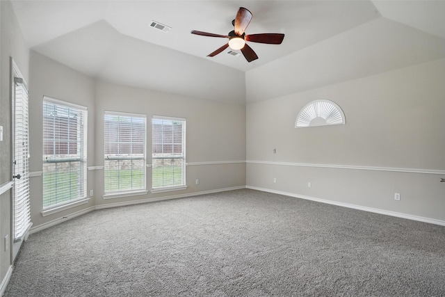 empty room featuring a wealth of natural light, ceiling fan, carpet, and visible vents