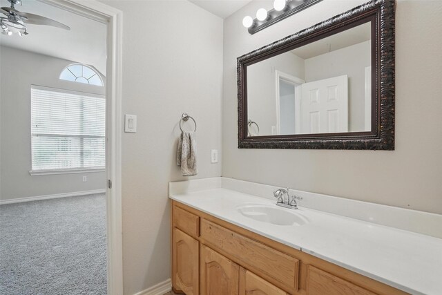 bathroom featuring vanity, plenty of natural light, baseboards, and a ceiling fan