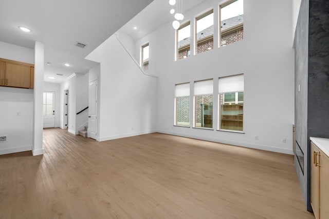 17546 Sequoia Dr, Dallas, TX 75252 - unfurnished living room with visible vents, light wood finished floors, baseboards, and stairway