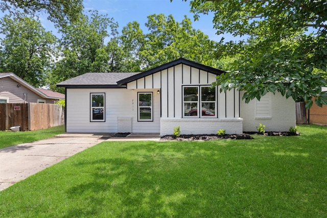 ranch-style home with board and batten siding and roof with shingles
