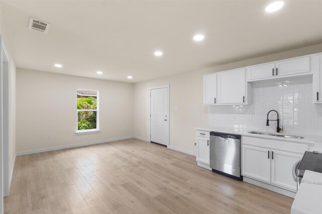 kitchen featuring stainless steel dishwasher, a sink, decorative backsplash, white cabinets, and recessed lighting