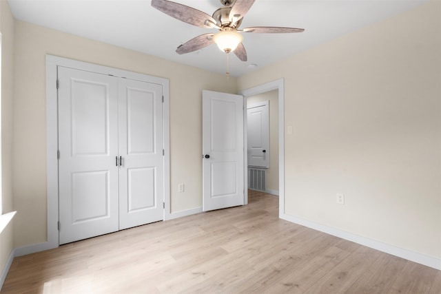 unfurnished bedroom with baseboards, light wood finished floors, and a closet