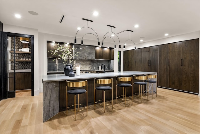 4280 Shorecrest Dr, Dallas, TX 75209 - kitchen with modern cabinets, light wood finished floors, dark brown cabinets, backsplash, and recessed lighting