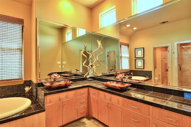 full bathroom with a healthy amount of sunlight, vanity, a shower stall, and visible vents