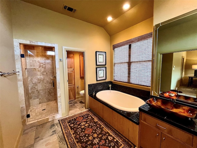 bathroom featuring visible vents, toilet, a bath, vaulted ceiling, and a tile shower