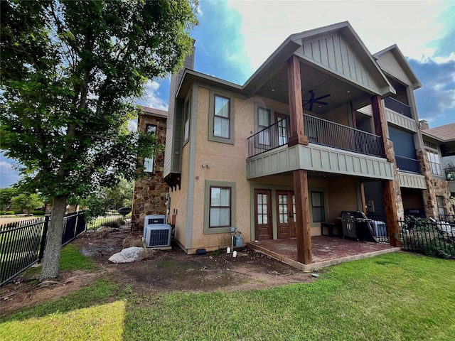 back of property featuring fence, stucco siding, a chimney, a ceiling fan, and a yard