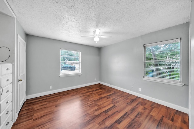 unfurnished bedroom with baseboards, dark wood-style floors, and a textured ceiling