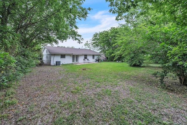 view of yard featuring french doors, a patio, and central AC unit