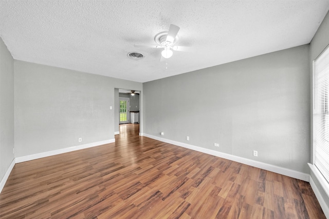 unfurnished room with baseboards, ceiling fan, visible vents, and wood finished floors