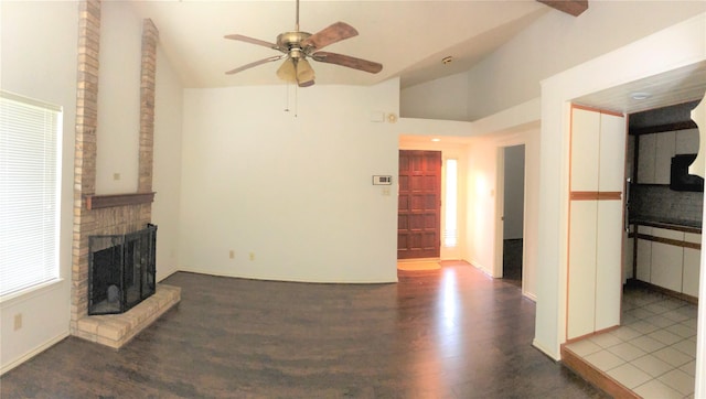 unfurnished living room with a brick fireplace, wood finished floors, baseboards, ceiling fan, and vaulted ceiling