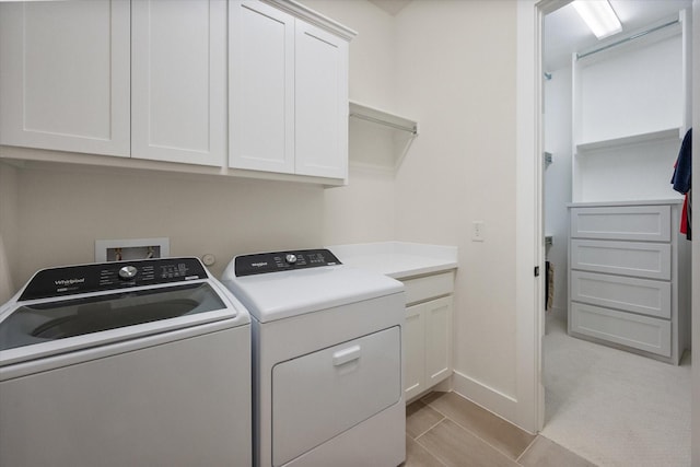 laundry room featuring cabinet space, baseboards, and washer and clothes dryer