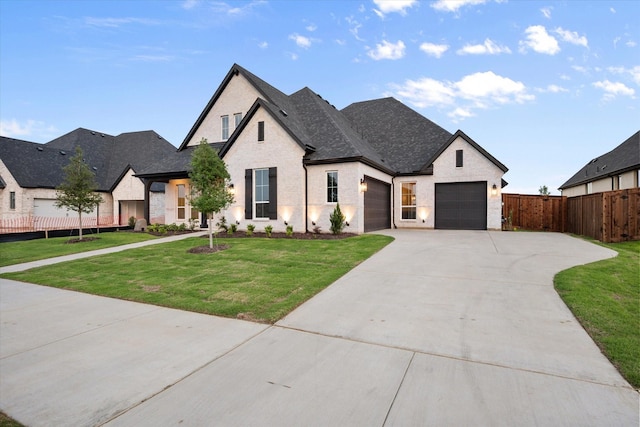 view of front of house with driveway, fence, a front lawn, an attached garage, and a shingled roof
