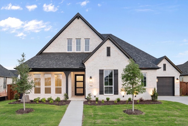 view of front of home with brick siding, driveway, a front lawn, and a garage