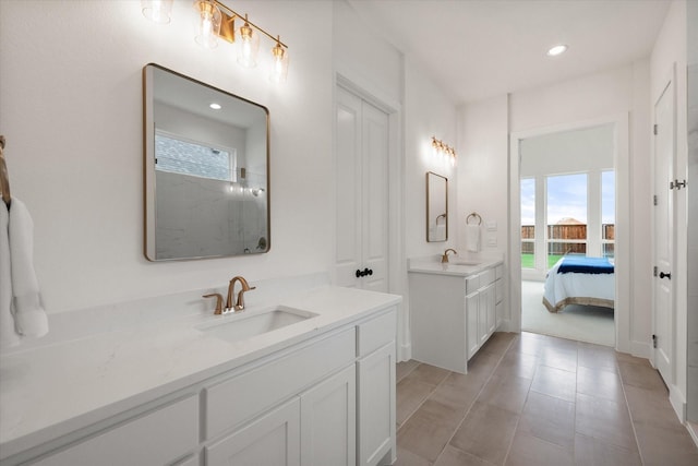 full bathroom featuring recessed lighting, two vanities, a sink, and a shower