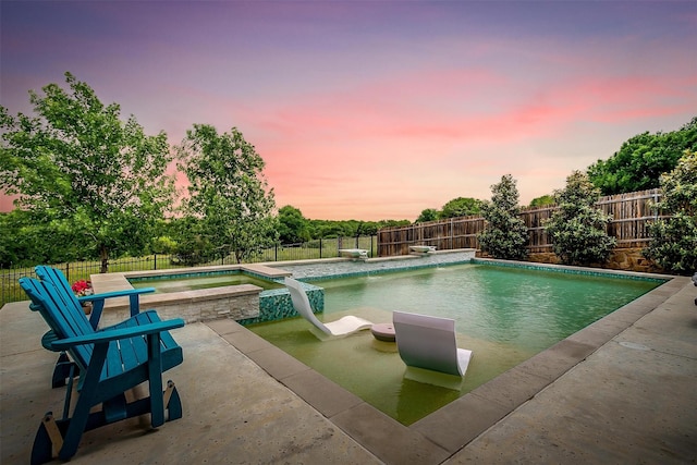 view of pool with a diving board, a fenced backyard, a patio area, and a pool with connected hot tub
