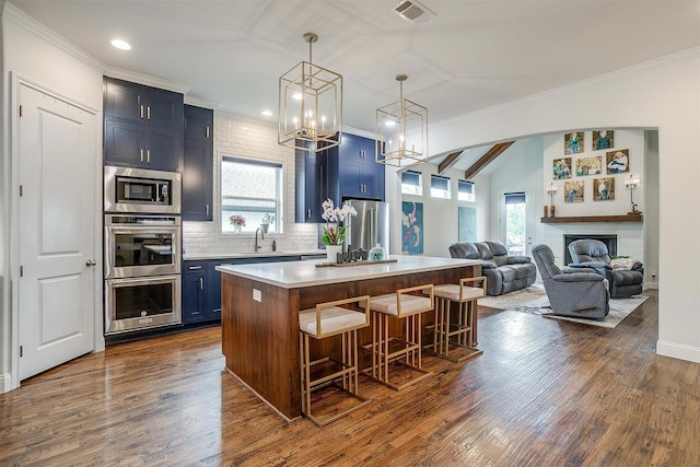 kitchen featuring visible vents, a kitchen breakfast bar, light countertops, a sink, and appliances with stainless steel finishes