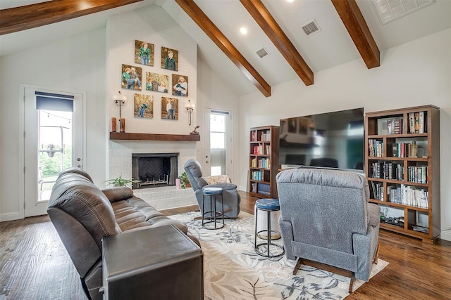 living room featuring beamed ceiling, high vaulted ceiling, visible vents, and wood finished floors
