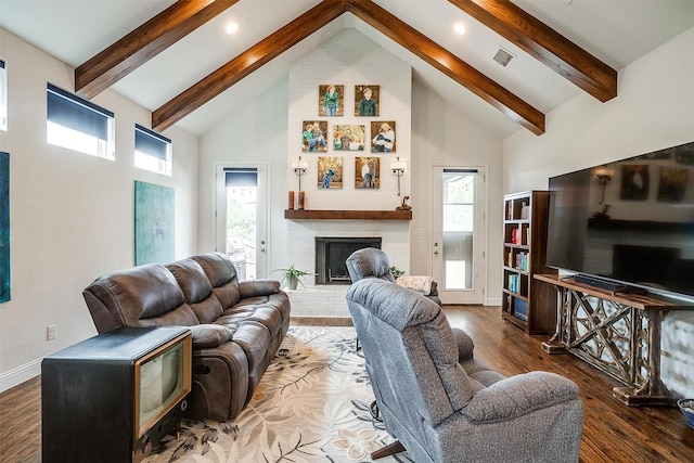 living room with visible vents, a brick fireplace, wood finished floors, high vaulted ceiling, and beamed ceiling