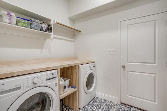laundry room featuring laundry area, baseboards, tile patterned flooring, and washing machine and clothes dryer