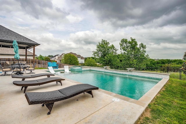 view of swimming pool featuring fence, a patio, and a pool with connected hot tub