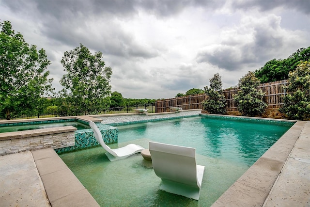 view of pool featuring a fenced in pool, a fenced backyard, and an in ground hot tub