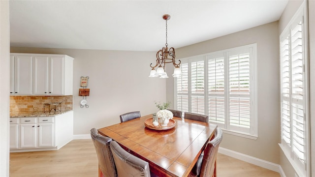 dining room featuring an inviting chandelier, light wood-style flooring, and baseboards