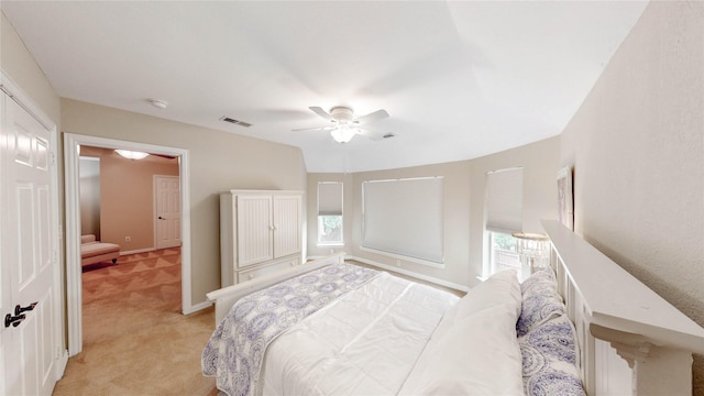 bedroom with multiple windows, light carpet, ceiling fan, and visible vents