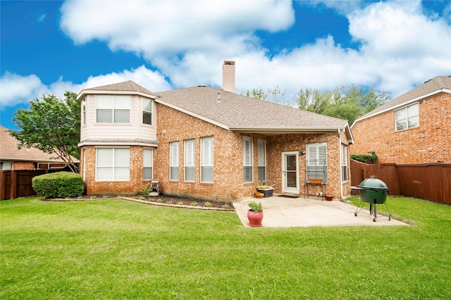 back of house with brick siding, a chimney, a patio, and a shingled roof