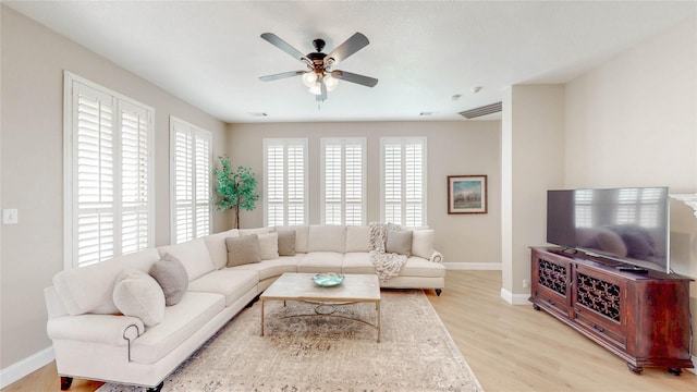 living area featuring visible vents, baseboards, light wood-style flooring, and ceiling fan