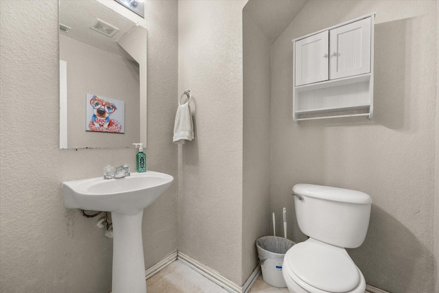half bath featuring toilet, visible vents, and a sink