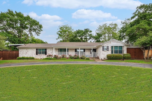 single story home featuring fence, a porch, a front lawn, and brick siding